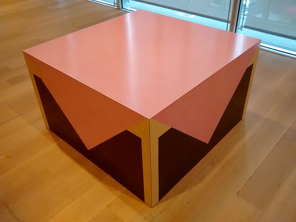 Table with Pink Tablecloth was exhibited— along with other compact, geometric masses wrapped with formica “pictures” so that they resemble domestic items—in his first solo show at the Leo Castelli Gallery, New York, in 1965.